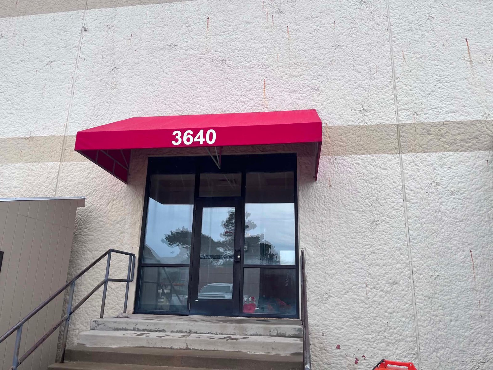 Red fabric awning over a commercial building entrance