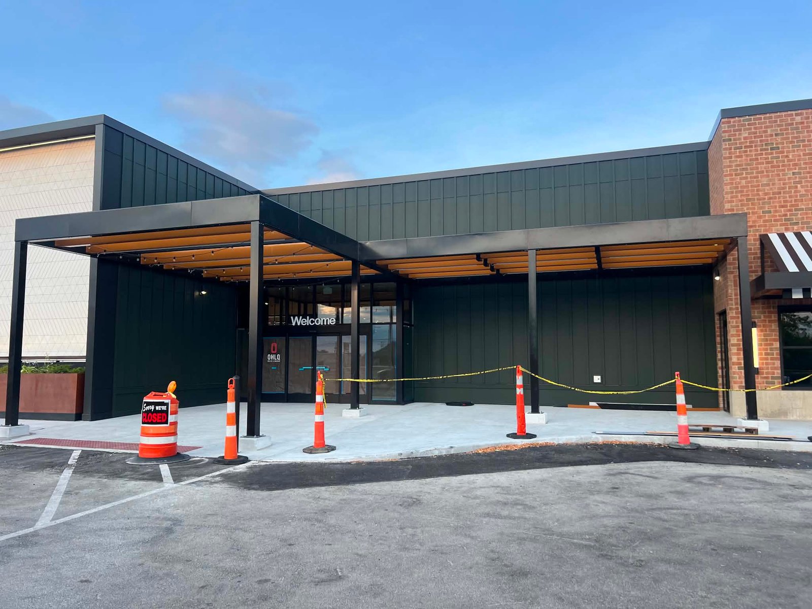 Large post-supported metal canopy covering a commercial entrance